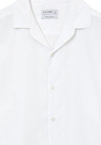 Camicia bianca con colletto corto, tre bottoni bianchi sul davanti, etichetta con il marchio "Calliope", taglia large, vestibilità regolare.