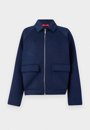Marineblaue, kurze Jacke aus weichem Stoff, mit einem Reißverschluss vorne, spitzem Kragen und zwei großen aufgesetzten Taschen.