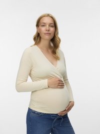 Beežika pika varrukaga pluus V-kaelusega, vöökohas vormis, rase modelli seljas, kombineeritud siniste teksadega. Siidine tekstuur.