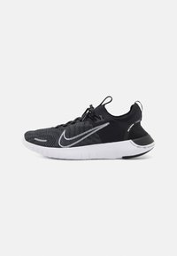Černé a šedé běžecké boty Nike Free s pleteným svrškem, texturovaným designem a bílým akcentem v podobě značky Swoosh. Disponují flexibilní bílou podrážkou.