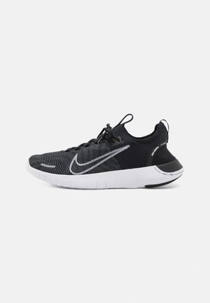 Schwarzer und grauer Nike Free Laufschuh mit einem gestrickten Obermaterial, strukturiertem Design und weißem Swoosh-Akzent. Verfügt über eine flexible weiße Sohle.