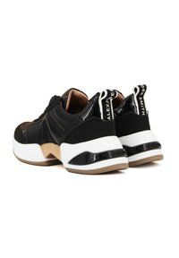 Zwarte sneakers met glanzende accenten, witte zool en beige details. Bevat een trekklep met logo en gestructureerde materialen op het bovenwerk.