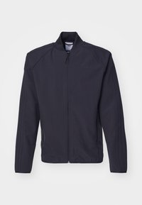 Tmavě modrá zipová bunda vyrobená z hladké tkaniny. Má stojáček, dvě boční kapsy a tři vertikální pruhy na každém rukávu.