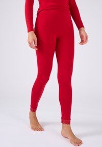 Rote Leggings aus dehnbarem Material mit Spitzenakzenten am Knöchel. Das Design ist figurbetont und glatt, mit einem hohen Bund.
