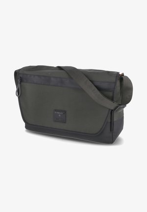 Sac messager vert foncé en tissu texturé avec fermeture à rabat, poche zippée et sangle réglable ; présente un patch logo.