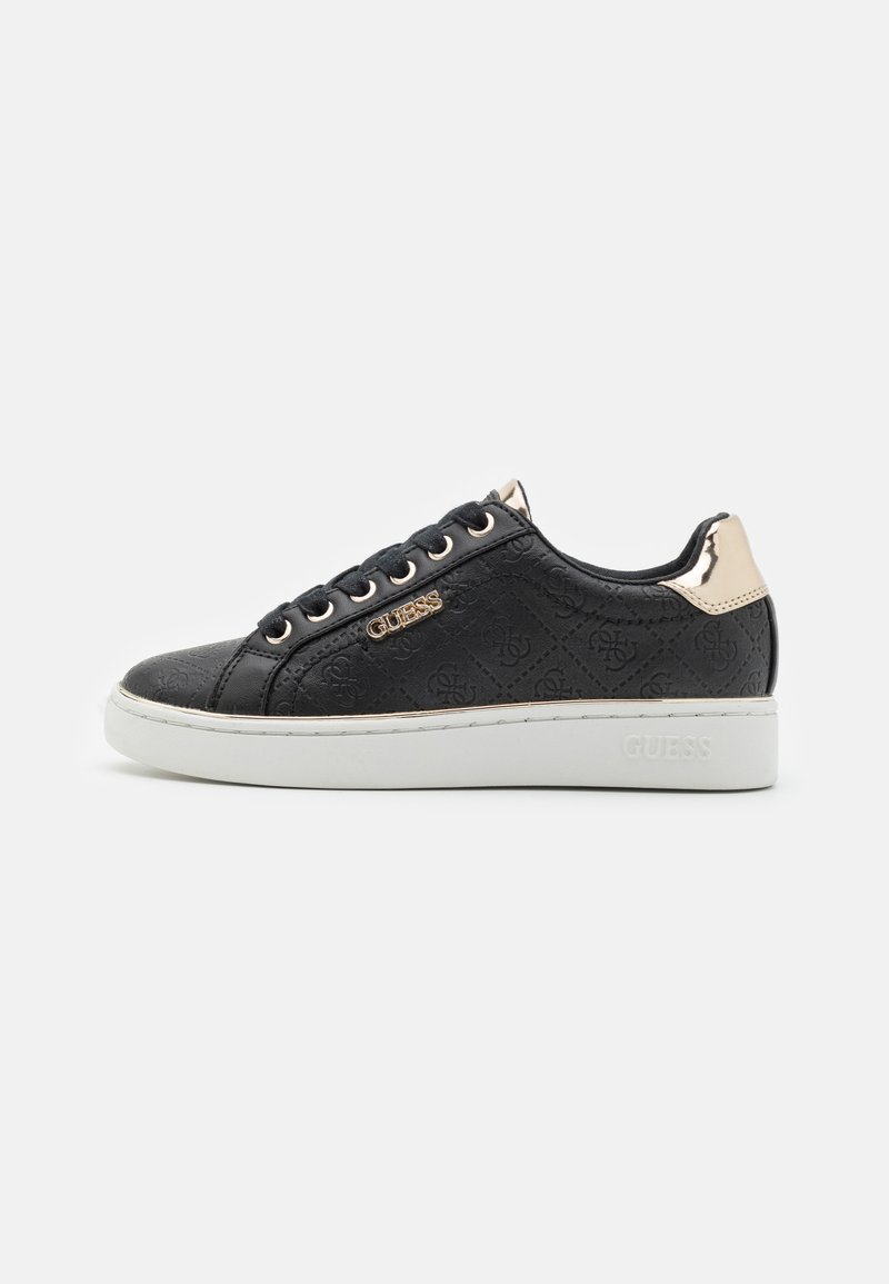 Sneaker nera con motivo del logo in rilievo, accentuato in oro sul tallone, suola bianca e lacci neri. Presenta una tomaia in tessuto liscio.
