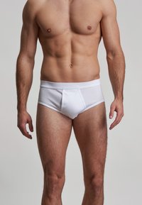 White cotton briefs with a fitted design, elastic waistband, and a smooth texture. Features a front pouch and seam details.