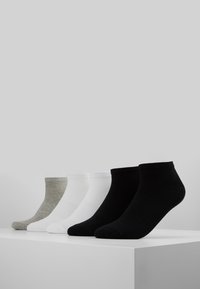Ein Set von Knöchelsocken in Grau, Weiß und Schwarz. Baumwollmischung mit gerippten Bündchen. Vier Paar auf einer weißen Oberfläche vor einem grauen Hintergrund präsentiert.