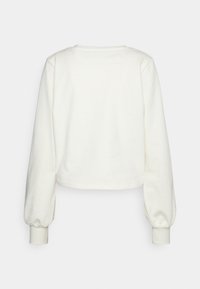 Top cropped a maniche lunghe in morbido tessuto bianco, con scollatura rotonda e polsini elasticizzati caratterizzati da una superficie liscia. Design semplice e minimal.