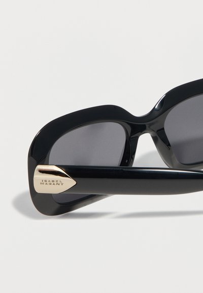 Μεγάλα μαύρα γυαλιά ηλίου με σκούρους φακούς και χρυσή μεταλλική λεπτομέρεια χαραγμένη με την επιγραφή "Isabel Marant" στο πλάι.