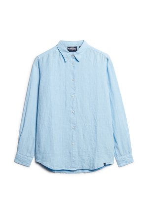 Chemise boutonnée bleu clair fabriquée en tissu doux et texturé, dotée d'un col, de manches longues et d'un ourlet incurvé. Petite étiquette avec logo en bas.
