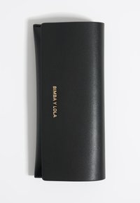 Cartera de cuero negro con una textura suave, que presenta un logo dorado en relieve "BIMBA Y LOLO" en la parte frontal, de forma rectangular y bordes redondeados.