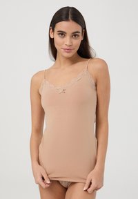 Camisola beige con pizzo lungo l'escote, spalline a farfalla, materiale in cotone morbido e un piccolo nodo decorativo al centro davanti.