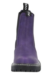Botín de piel púrpura con paneles laterales elásticos, tirador y suela de goma negra. Presenta costuras blancas a lo largo de la suela.