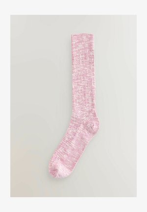 Ružové a biele melírované pletené ponožky po kolená s rebrovanou textúrou položené na neutrálnom pozadí.