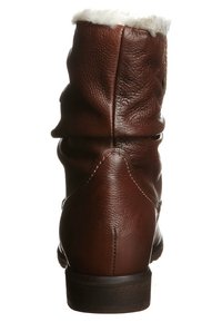 Botte en cuir marron mi-mollet avec un petit talon et une doublure en polaire blanche visible en haut, vue de dos.