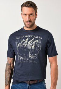 Tmavě modré bavlněné tričko s grafikou medvěda a lesní scenérií, s textem "BEAR CREEK FALLS" a "NÁRODNÍ PARK GLACIER - KANADA."