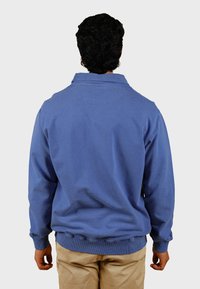 Maglione di cotone blu con colletto, polsini e orlo a costine. Texture liscia, vestibilità comoda, senza motivi o grafiche visibili.