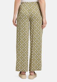 Wijduitlopende broek in een levendige groene, gele en roze patroon van diamanten en bloemen. Gemaakt van lichtgewicht stof, met een comfortabele tailleband.