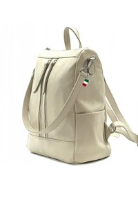 Crème-kleurige leren rugzak met een gestructureerde afwerking, voorzien van een bovenste rits, twee voorzakken en verstelbare schouderbanden. Accenten van de Italiaanse vlag.