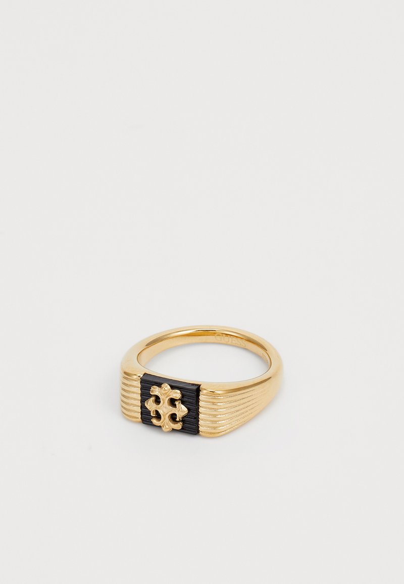Goudkleurige metalen ring met een zwarte gestructureerde band en een decoratieve gouden accent in het midden met een uitsnijdpatroon.