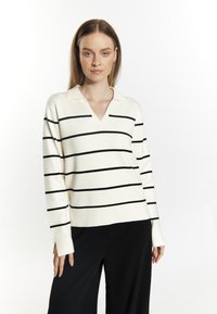 Pullover color crema con righe orizzontali nere, design a V, maniche lunghe e una texture morbida. Adatto per un abbigliamento casual.