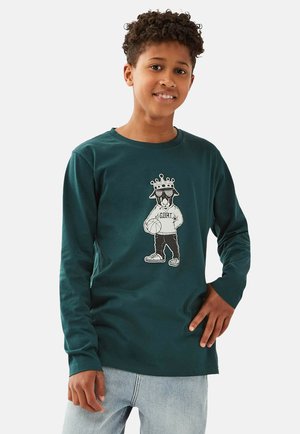 Türkisfarbenes Langarm-T-Shirt aus Baumwolle. Mit einem Grafikdruck eines Cartoon-Charakters, der eine Krone trägt und einen Basketball hält.