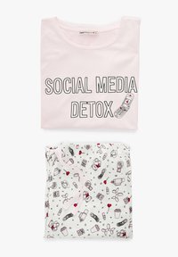 Camiseta de algodón rosa con el texto negro "DESINTOXICACIÓN DE REDES SOCIALES". Debajo, pantalones de pijama blancos con dibujos juguetones en rojo y negro, que presentan varios elementos.