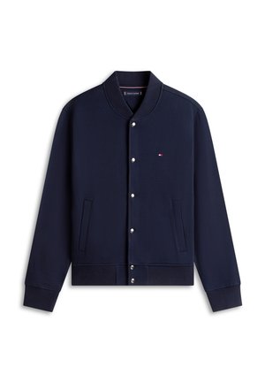 Marineblaue Bomberjacke mit Druckknöpfen, geripptem Kragen, Bündchen und Saum, zwei Vordertaschen und einem kleinen rot-weiß-blauen Logo auf der Brust.