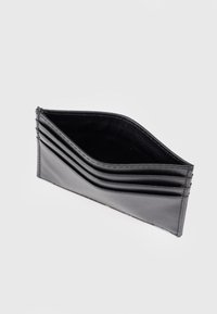 Μαύρο δερμάτινο θήκη κάρτας με πολλαπλές θήκες και ομαλή υφή. Διαθέτει κομψό, μίνιμαλ σχεδιασμό και διακριτικές ραφές.