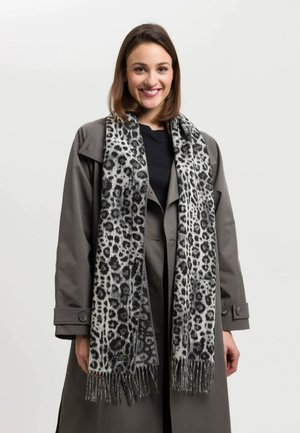 Sciarpa grigia con stampa leopardata, tessuto morbido, bordi frangiati, forma rettangolare allungata. Indossata con un cappotto scuro, mette in mostra i dettagli del motivo.