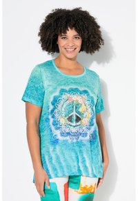 Tyrkysové tričko s tie-dye designem, které zobrazuje mírový symbol obklopený květinovými detaily a textem „Happy Hippie Life“ v bílé barvě. Krátké rukávy, kulatý výstřih.