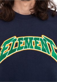 Felpa navy con testo ricamato verde e giallo "ELEMENT" in un design curvo. Tessuto morbido con scollo a coste.