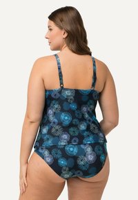Set da bagno tankini con sfondo blu navy e motivi floreali in teal e blu chiaro. Spalline regolabili e design con copertura modesta.