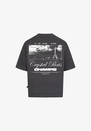 Grijze T-shirt met korte mouwen en een oversized pasvorm. Heeft een zwart-wit grafiek van de Eiffeltoren en tekst: "Crystal Paris CHAMPS" op de achterkant.