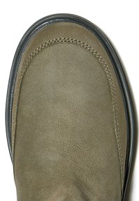 Olivově zelená semišová bota s kulatou špičkou, která má hladký povrch a kontrastní prošití podél švu, a černou gumovou podrážku.