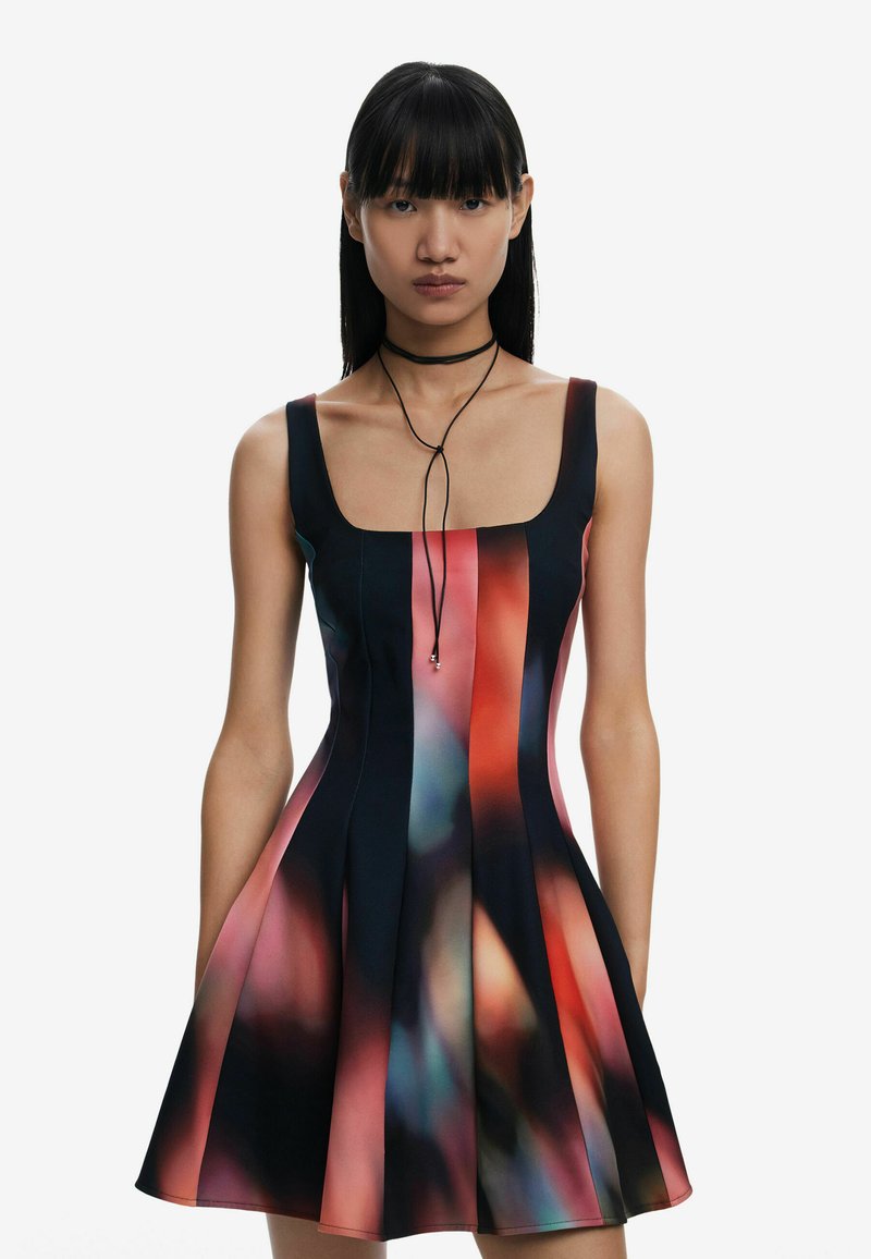 Black and pink sleeveless dress with a square neckline, featuring an abstract pattern and flared hem. Model wearing a black choker.