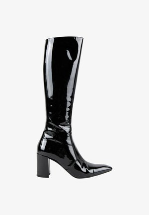 Botte noire brillante jusqu'au genou avec un bout pointu et un talon haut et épais, vue de côté sur fond blanc.