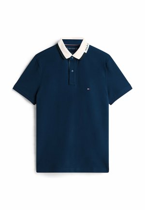 Polo shirt blu navy con colletto bianco, patta con due bottoni e piccolo logo sul petto. Maniche corte e texture liscia.