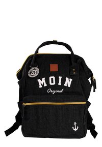 Black denim backpack with yellow zipper, white lettering "MOIN Original," anchor design, and brown leather patch. Two front pockets.