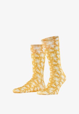 Gelbe Socken bis zur Mitte der Wade mit weißen, abstrakten Blumen- und Blattmustern, nebeneinander stehend auf einem weißen Hintergrund.