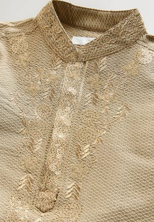 Vyšívaná látka zlatej farby s textúrovanými vzormi, flitrovými detailmi a mandarínskym golierom, s centrálnou légiou na gombíky.