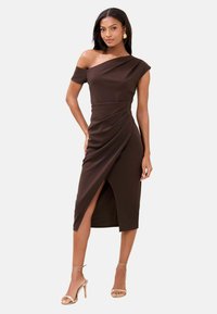 Robe marron épaules dénudées avec une silhouette ajustée, un design drapé, un ourlet à hauteur du genou et une fente latérale. Texture de tissu lisse, détails minimalistes.