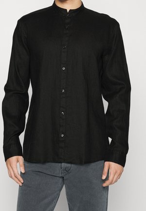 Chemise noire à manches longues en lin avec un col mandarin, dotée de boutons noirs et d'une coupe décontractée. Tissu texturé avec un léger éclat.