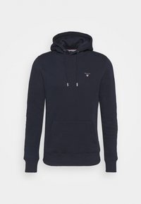 Sudadera con capucha de color azul marino, hecha de algodón; cuenta con un bolsillo frontal tipo canguro, cordones con puntas de metal y un pequeño logo en el pecho.