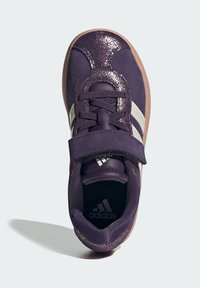 Fialová sportovní bota s metalickými akcenty, bílými pruhy, šněrovacím designem a suchým zipem; gumová podrážka pro lepší trakci.