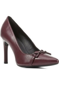 Scarpa con tacco alto da donna in pelle bordeaux, a punta, con dettaglio decorativo a nodo sul davanti e rivestimento interno nero.