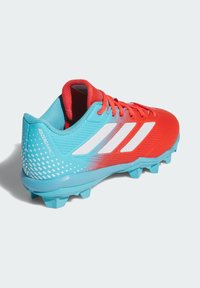 Crveno-plavi nogometni kopački s teksturiranim gornjim dijelom, tri bijele pruge i točkastim uzorkom na peti. Ima lagani dizajn.