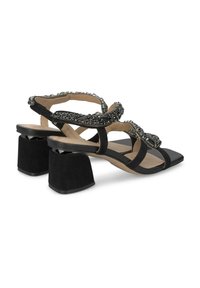 Schwarze High Heel Sandalen mit quadratischer Zehenpartie und kantigem Blockabsatz. Sie verfügen über verzierten Riemen mit Perlen und einer glatten, wildlederähnlichen Textur.
