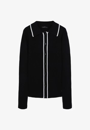 Schwarze gerippte Strickjacke mit weißem Kragen und zwei weißen Streifen entlang der Knopfleiste. Verfügt über lange Ärmel und schwarze Knöpfe.
